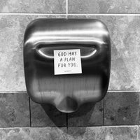 Hand dryer with a motivational message on a tiled wall