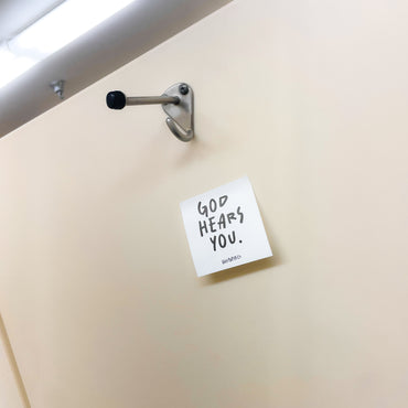 Note with 'God hears you' text on a door handle