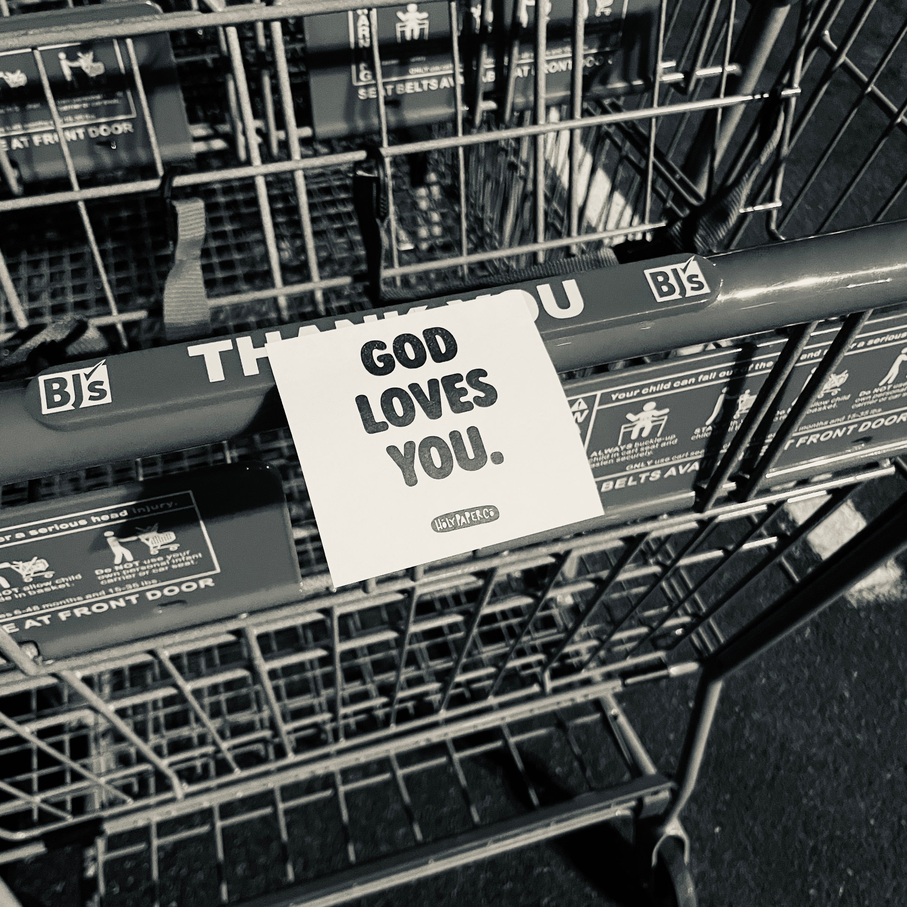 Shopping cart with a 'GOD LOVES YOU' tracts on handle